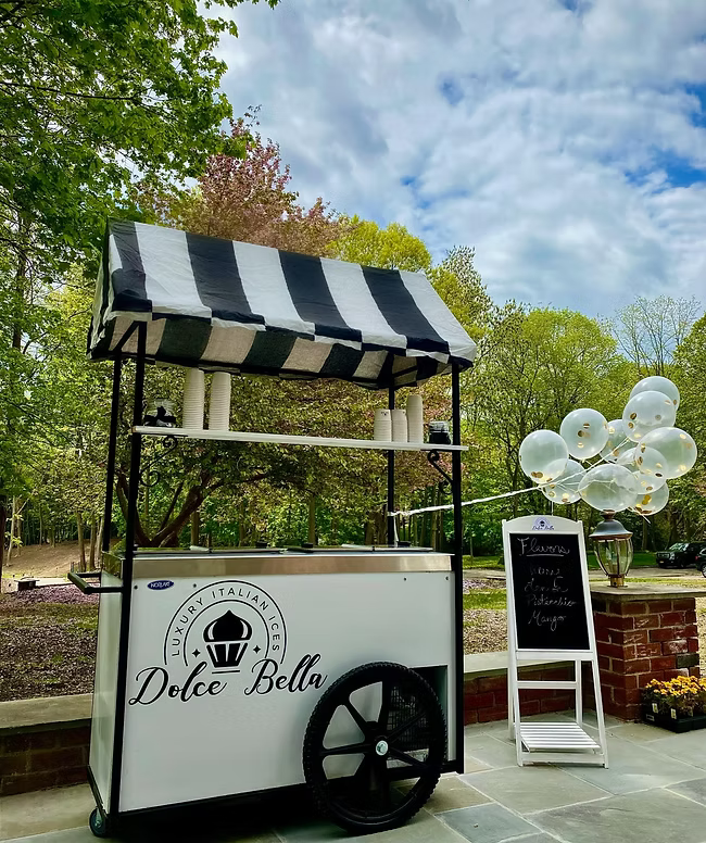 Dolce Bella dessert cart with striped canopy in a park setting